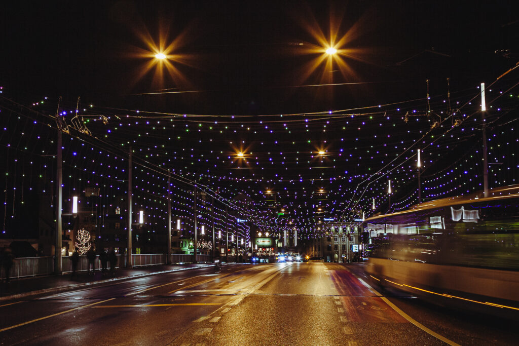 Nächtliche Strasse mit Lichterketten und Laternen